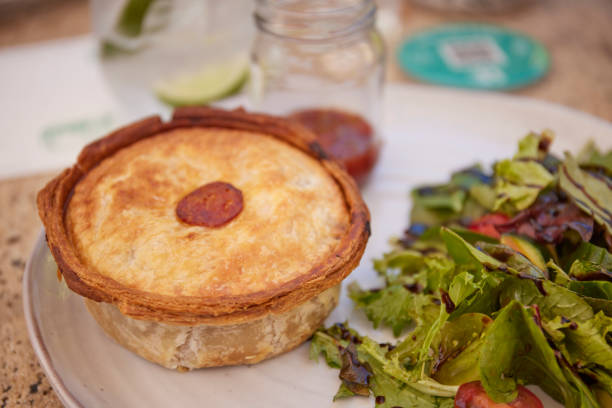 Australian meat pie with flaky pastry and gravy